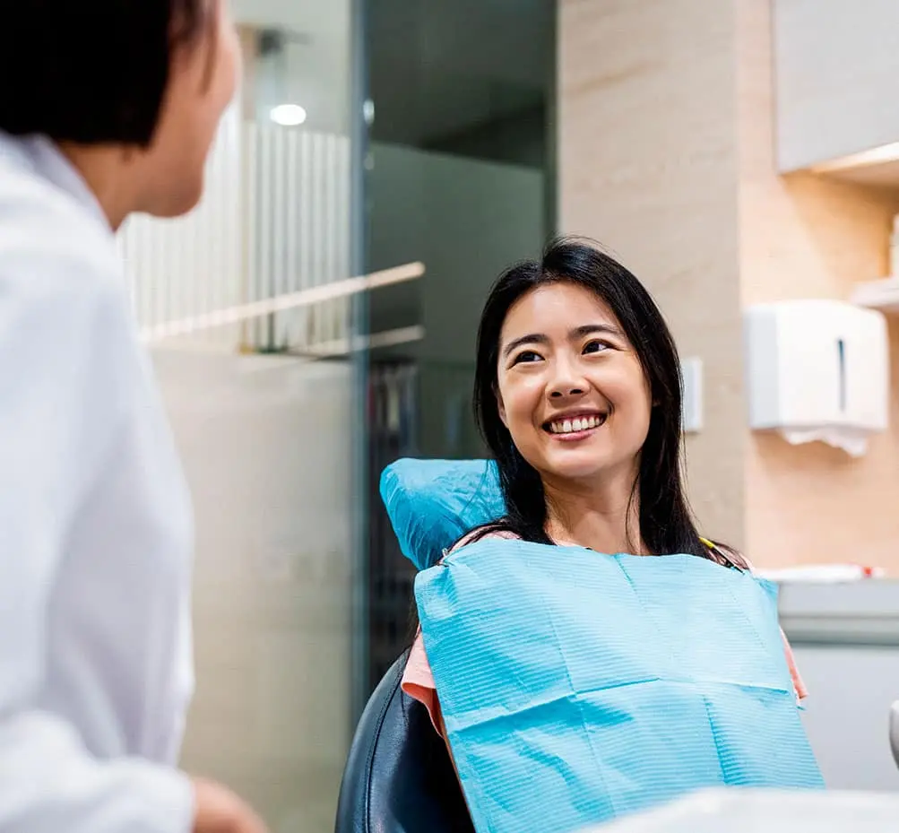 Patient smiling in the dental chair during a porcelain veneer consultation