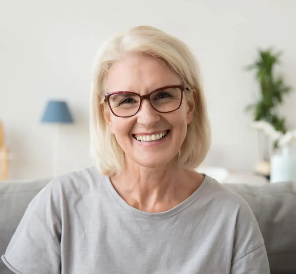 Senior patient smiling after restorative dental treatment at Sierra Springs Dental in Airdrie
